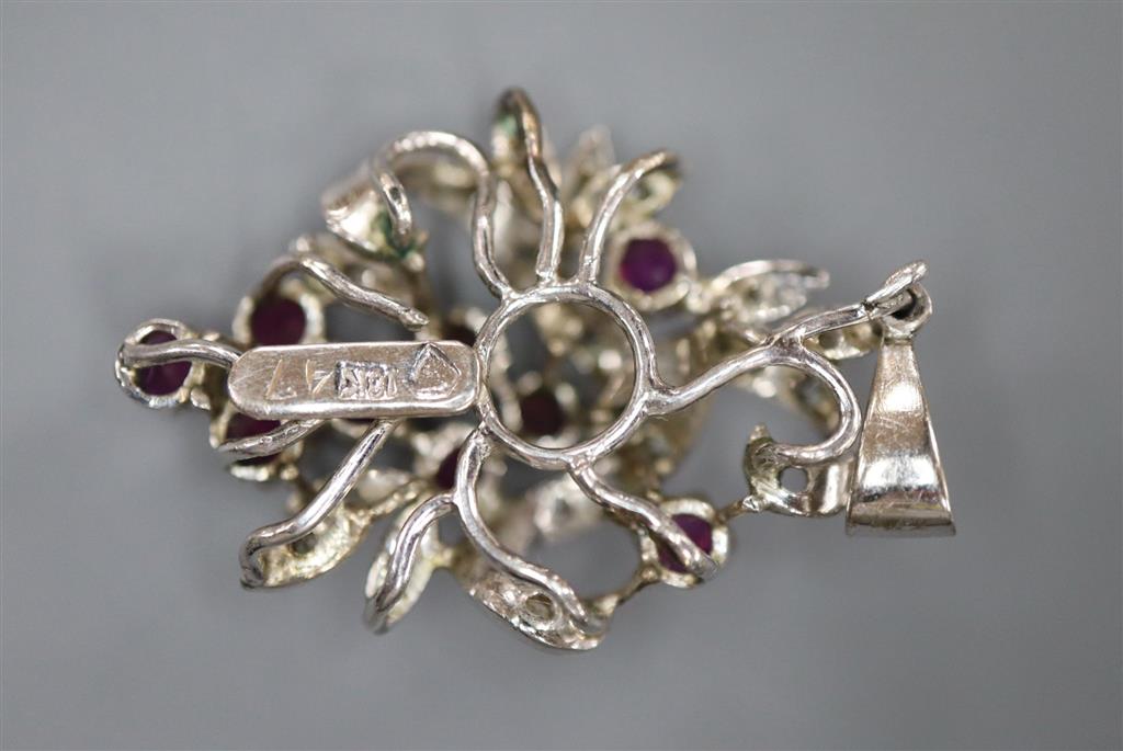 A modern 18k white metal, ruby and diamond chip set scroll pendant, 30mm, gross 5.6 grams.